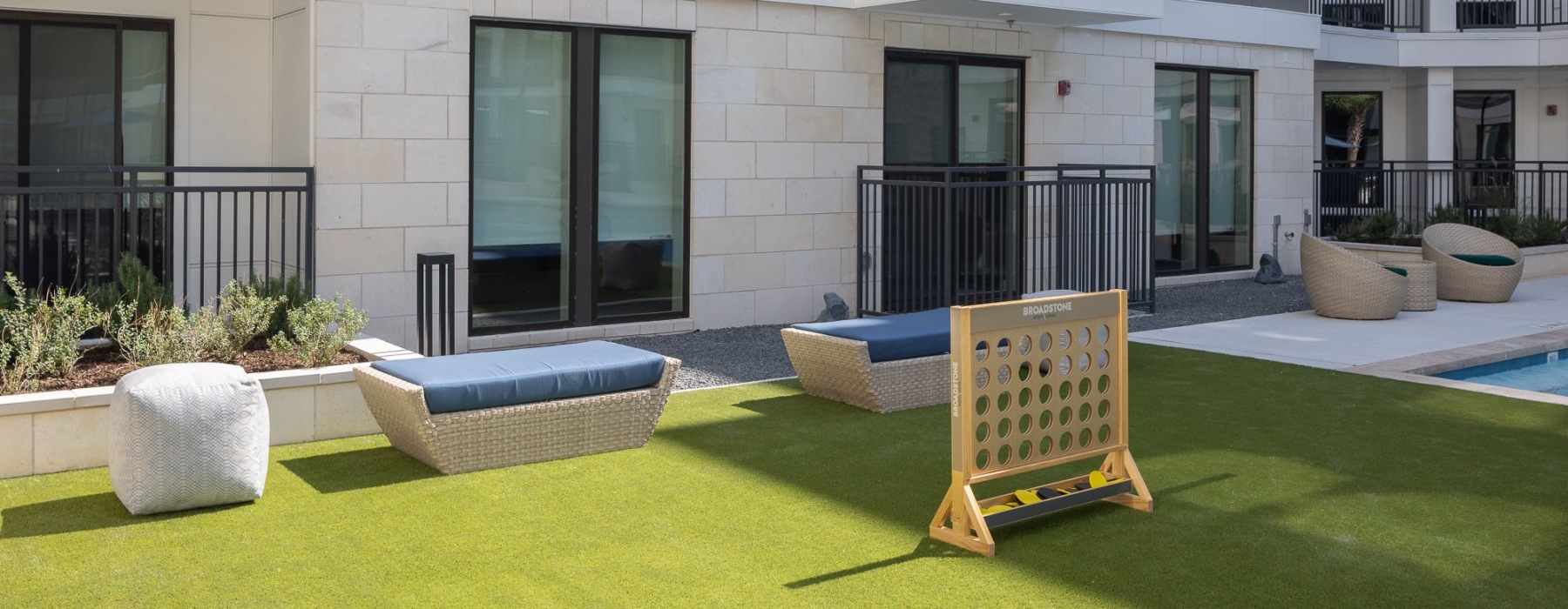 outdoor green area with games next to the pool